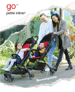famille avec deux enfants en bas âge se promenant dans un jardin de parc en poussant la poussette go™ inline™